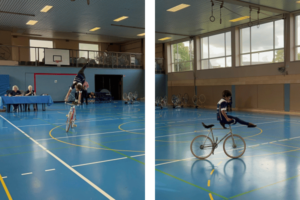 Das Bild zeigt zwei Kinder auf einem Kunstrad. Ein Kind steht auf dem Sattel und streckt dabei ein Bein nach hinten in die Luft. Das andere Kind sitzt auf dem Lenker und streckt seine Beine nach vorne aus.