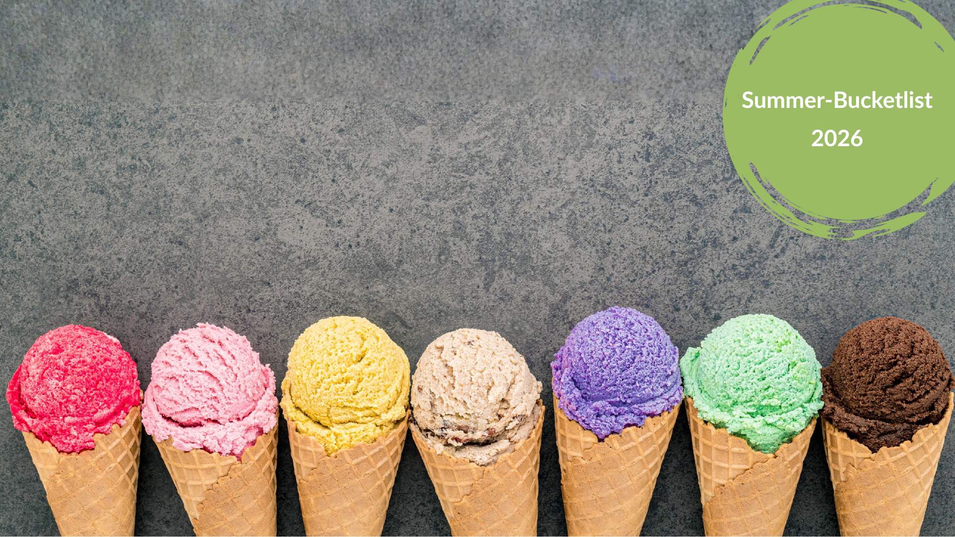 Bunte Eiskugeln in Waffeltüten in einer Reihe auf grauem Steinhintergrund – Titelbild der Summer-Bucketlist 2026.