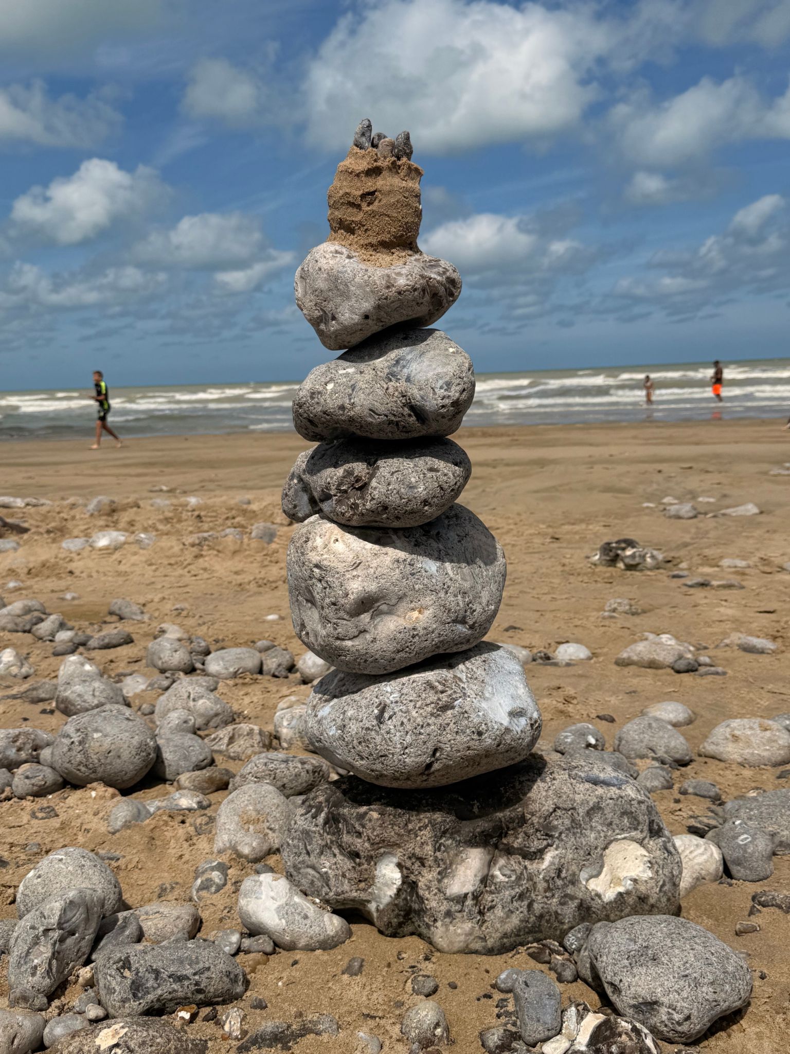 Balancierter Steinturm aus Kieseln an einem Strand in der Bretagne, Sinnbild für Balance und Achtsamkeit im Moment.
