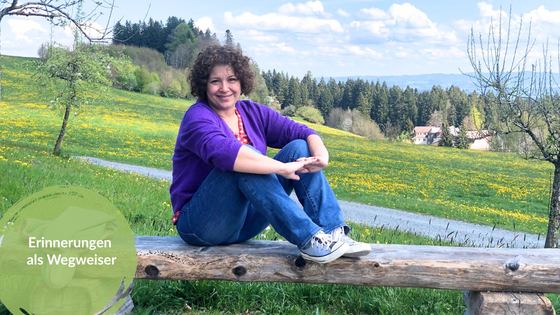 Pia Hübinger sitzt auf einer Holzbank vor einer Löwenzahnwiese im Allgäu, mit dem Titel „Erinnerungen als Wegweise"